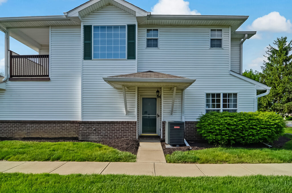 Front exterior view of Property 4 townhome with entry path and lawn