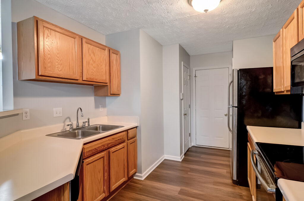 Kitchen with wooden cabinetry, sink, and refrigerator at Property 4