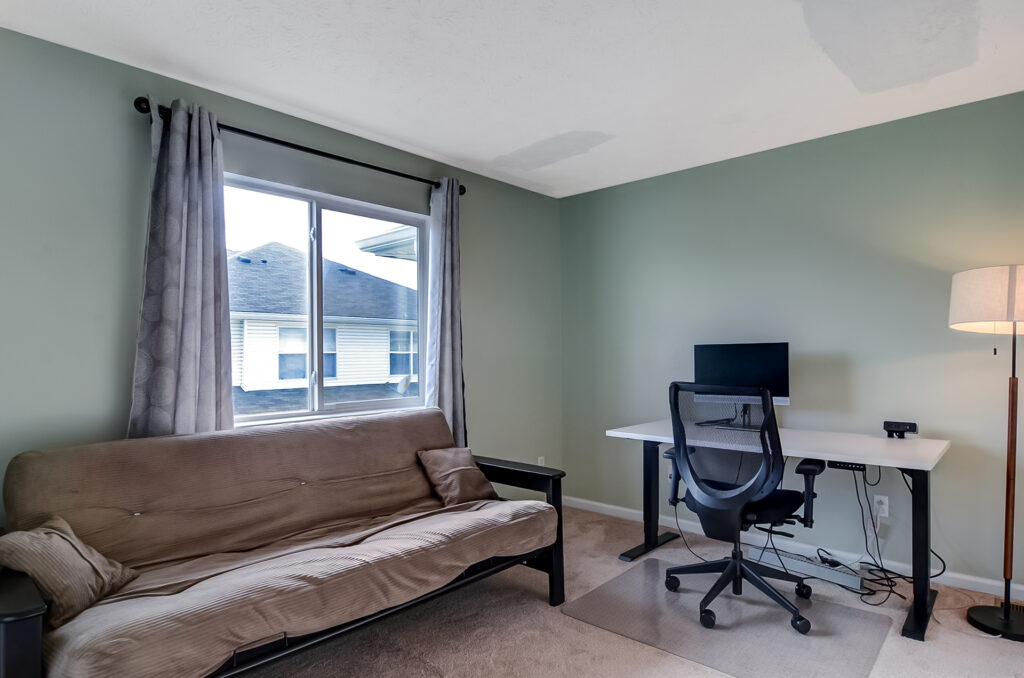 Multifunctional room with desk setup and futon for office or guest use