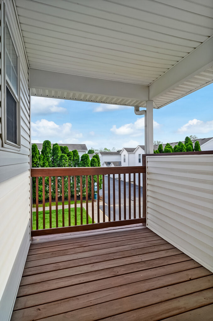 Covered second-floor balcony with neighborhood view at Property 4